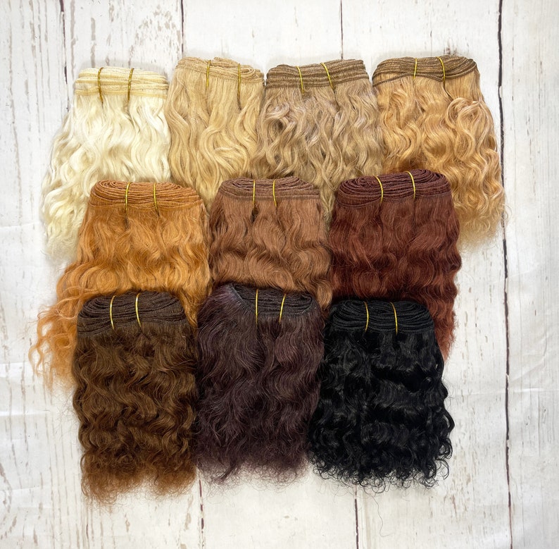 May include: A set of ten wefts of curly human hair extensions in various shades of blonde, brown, and black.