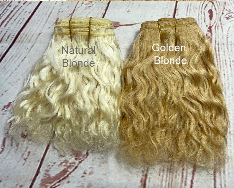May include: Two bundles of wavy human hair extensions, one labeled "Natural Blonde" and the other labeled "Golden Blonde".