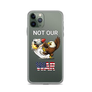 May include: Clear phone case featuring a cartoon bald eagle attacking a missile. The text "NOT OUR WAR" is displayed in white and red, white, and blue. The eagle is brown and white with yellow talons and a fierce expression.