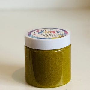 Pode incluir: Um pequeno frasco de slime verde com um r&oacute;tulo colorido que diz "Slime" e "Eggos May" em uma fonte caprichosa.