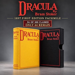 Puede incluir: Un libro de tapa dura amarillo titulado Dracula de Bram Stoker, facs&iacute;mil de la primera edici&oacute;n de 1897, junto a un estuche negro con el mismo t&iacute;tulo en letras rojas. El texto superior dice Dracula By Bram Stoker 1897 FIRST EDITION FACSIMILE 56 OF 100 CLAIMED ONLY 44 REMAIN.