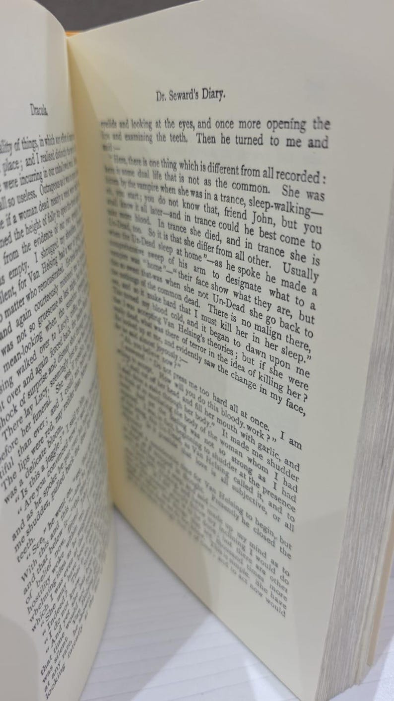 Puede incluir: Un libro abierto con p&aacute;ginas blancas y texto impreso en negro. La p&aacute;gina derecha es claramente visible, con el encabezado Dr. Seward's Diary. El texto trata sobre un vampiro, el sonambulismo y los muertos vivientes, con p&aacute;rrafos visibles.