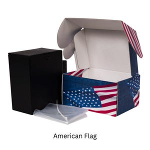 May include: An open cardboard box with an American flag design, featuring blue, white, and red colors. A black box and a clear plastic bag are next to the box. The text "American Flag" is at the bottom.