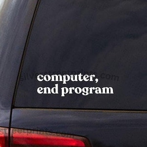 May include: A white vinyl sticker on the back window of a black car. The sticker says "computer, end program".