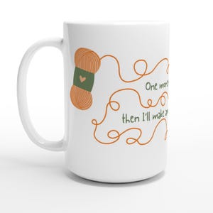 Può includere: Tazza in ceramica bianca con un disegno di gomitolo di lana arancione e un'etichetta verde con un cuore. La tazza ha il testo "One more... then I'll make..." in verde e arancione. La tazza ha un manico grande.