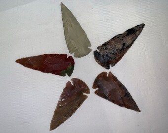 Puede incluir: Cinco puntas de flecha de diferentes colores y patrones dispuestos en forma de estrella sobre un fondo blanco.