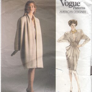 Puede incluir: Patrón de costura Vogue Patterns con un diseño de Donna Karan. La portada muestra a una mujer con un abrigo largo y claro y un boceto de un vestido con cinturón. El texto incluye "American Designer" y "Easy/Facile".