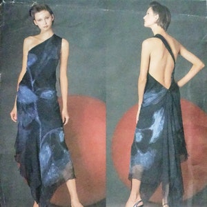 Può includere: Un modello Donna Karan New York Vogue American Designer con un abito monospalla con stampa floreale blu e nera. L'abito ha la schiena scoperta e una gonna drappeggiata. La modella indossa tacchi neri.