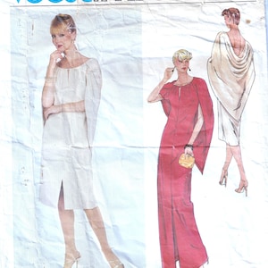 May include: A vintage Vogue Paris Original sewing pattern with designs by Pierre Balmain. The pattern shows illustrations of dresses with cape sleeves. The text "Vogue Paris Original" is at the top.