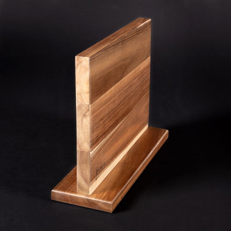May include: A wooden magnetic knife holder with a dark brown finish. The holder has a rectangular base and a vertical magnetic strip for holding knives.