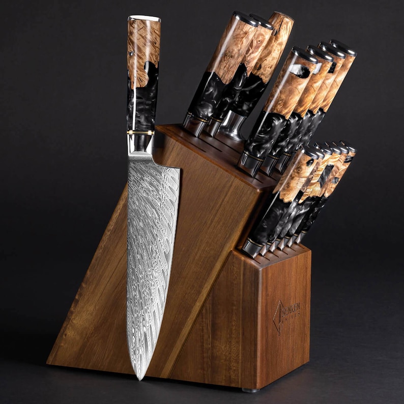 May include: A set of kitchen knives in a wooden block. The knives have patterned steel blades and handles with a mix of black and light brown wood grain. The wooden block is a warm brown color.