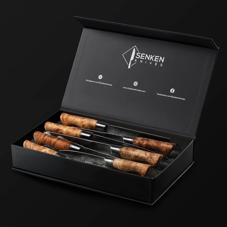 May include: A set of four knives with polished metal blades and textured light brown wooden handles, presented in a black rectangular box. The interior lid features the white text Senken Knives and social media icons with URLs.