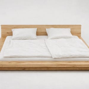 Puede incluir: Una moderna cama con plataforma de madera clara. La cama tiene un dise&ntilde;o de perfil bajo con cabecero y marco rectangular. Est&aacute; cubierta con ropa de cama blanca, que incluye una s&aacute;bana bajera, edred&oacute;n y dos almohadas. Medidas en cent&iacute;metros.