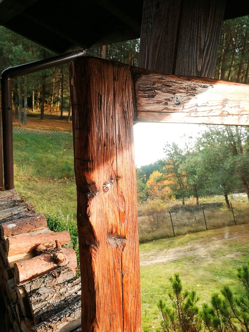 Puede incluir: Un espejo de madera r&uacute;stico con un acabado de madera natural. El espejo est&aacute; enmarcado con gruesas tablas de madera envejecidas. El espejo refleja una vista de un c&eacute;sped verde y &aacute;rboles.