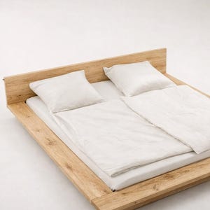 Puede incluir: Una moderna cama de madera con cabecero, con ropa de cama y almohadas blancas. El marco de la cama es de madera clara y tiene un dise&ntilde;o minimalista. La cama mide aproximadamente 200 cm de largo y 152 cm de ancho.