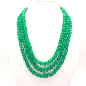 Op de afbeelding: Een meerstrengs ketting gemaakt van groene jade kralen. De kralen zijn rond en hebben een gladde, gepolijste afwerking.