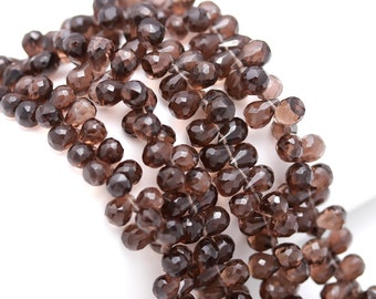 May include: A strand of brown faceted gemstone beads. The beads are teardrop shaped and have a smooth, polished finish.