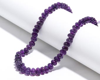 May include: A strand of purple amethyst beads, each bead is faceted and has a slightly rounded shape.