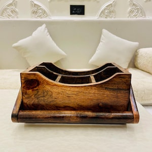 Puede incluir: Organizador de escritorio de madera oscura hecho a mano con múltiples compartimentos. El organizador tiene un diseño superior curvo y está hecho de madera oscura. Diseñado para guardar varios útiles de oficina.