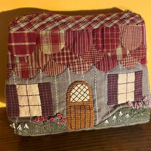 Nécessaire rústica em patchwork com bordado à mão e cobertura marrom.