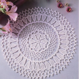 May include: White crocheted doily with a delicate floral design. The doily is circular and has a lace border.