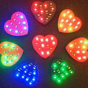 May include: Seven heart-shaped LED light panels with different coloured lights. The lights are red, orange, yellow, green, blue, and purple.