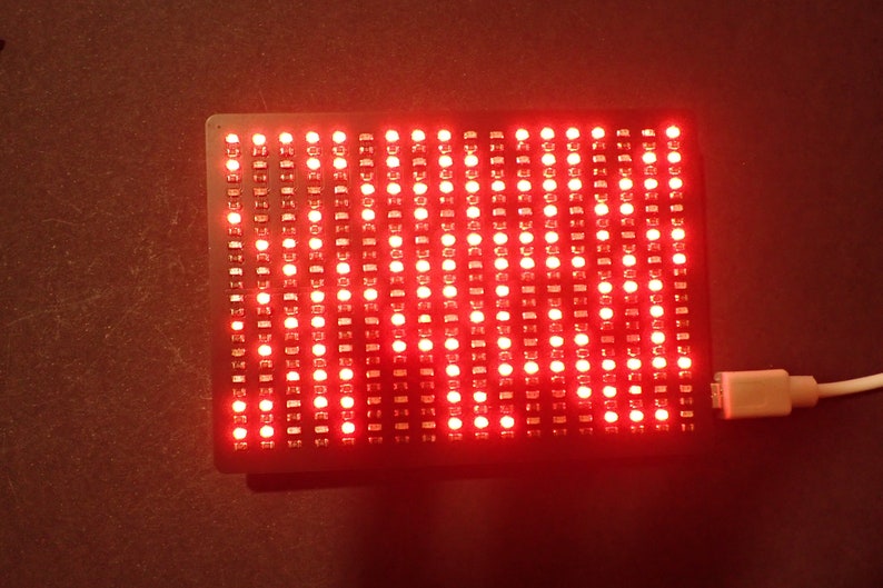 K&ouml;nnte beinhalten: Ein rotes LED-Matrix-Display mit schwarzem Rahmen und einem angeschlossenen USB-Kabel.