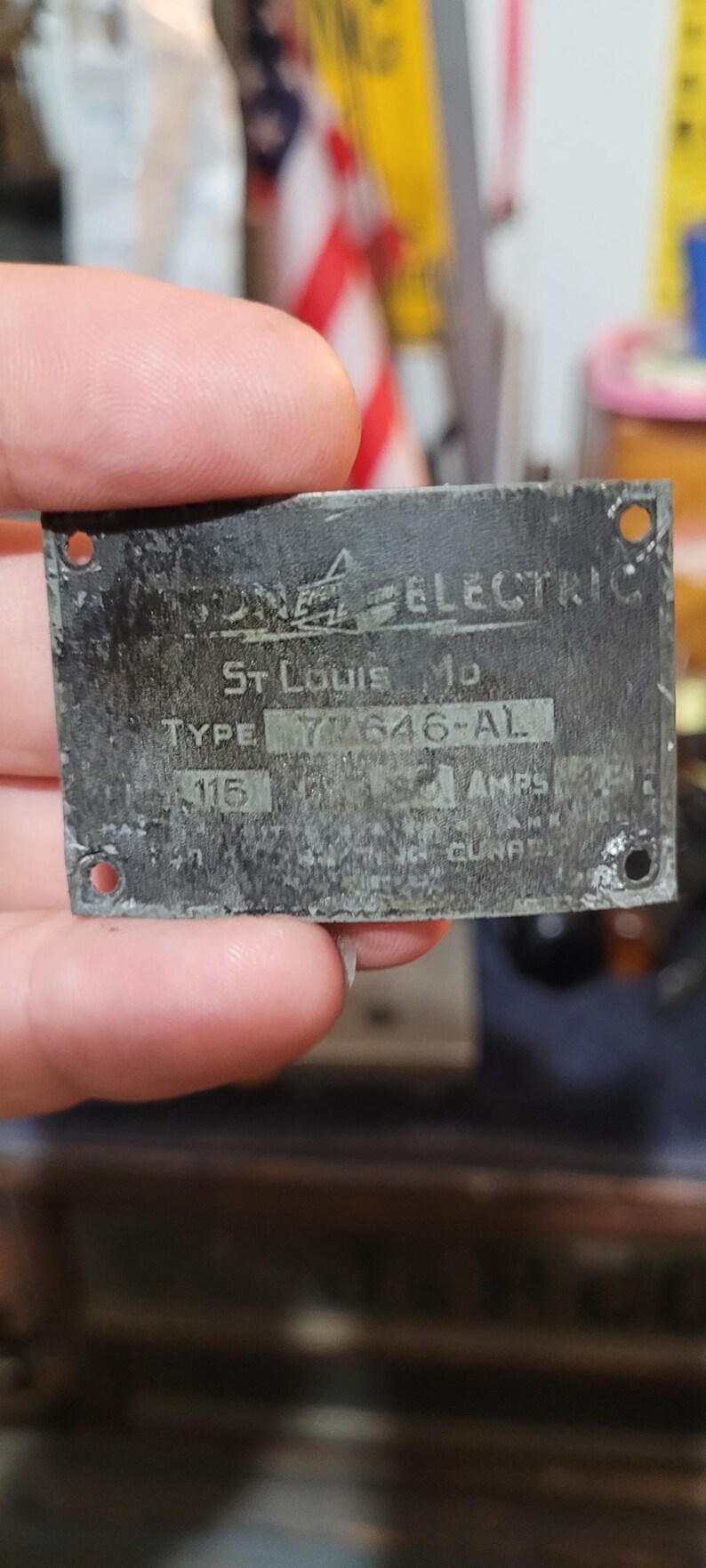 Puede incluir: Una placa met&aacute;lica desgastada con el texto "Wagner Electric" y "St. Louis Mo." La placa tiene el tipo "77646-AL" y "115 AMPS" impresos. Hay cuatro agujeros en las esquinas.