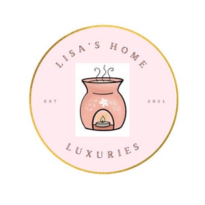 May include: A pink circle with a gold outline and the text "Lisa's Home Est 2021 Luxuries" around the edge. In the center is a cartoon image of a pink oil diffuser with a white flower design and a lit candle inside.