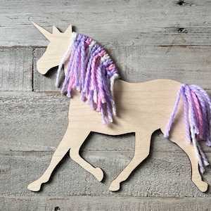 May include: Wooden unicorn cutout with a purple and pink yarn mane and tail.