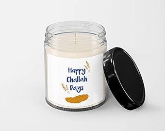 May include: A clear glass candle jar with a white label that reads "Happy Challah Days". The label features a graphic of a braided challah bread and wheat stalks. The candle jar has a black lid.