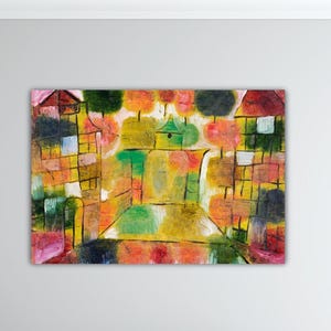 May include: Abstract painting with a colorful cityscape. The artwork features buildings and trees in shades of yellow, green, red, and orange. The painting has a textured appearance and is mounted on a white wall.
