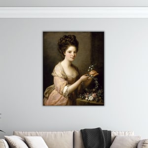 Könnte beinhalten: Ein klassisches Porträt einer Frau in einem rosa Kleid, die Blumen hält. Die Frau hat dunkles Haar und betrachtet die Blumen. Das Gemälde ist vor einem neutralen Hintergrund entstanden.