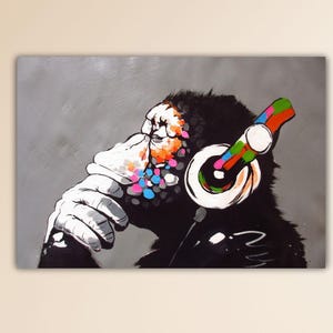 May include: A black and white illustration of a monkey wearing colorful headphones. The monkey's face is covered in colorful paint splatters.