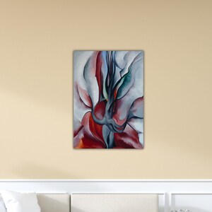 May include: Abstract floral painting with a palette of red, white, gray, and teal. The artwork features soft, curved shapes and lines, creating a sense of movement and depth. The painting is mounted on a rectangular canvas.