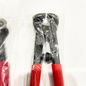 May include: A pair of black metal wire cutters with red handles, packaged in plastic.