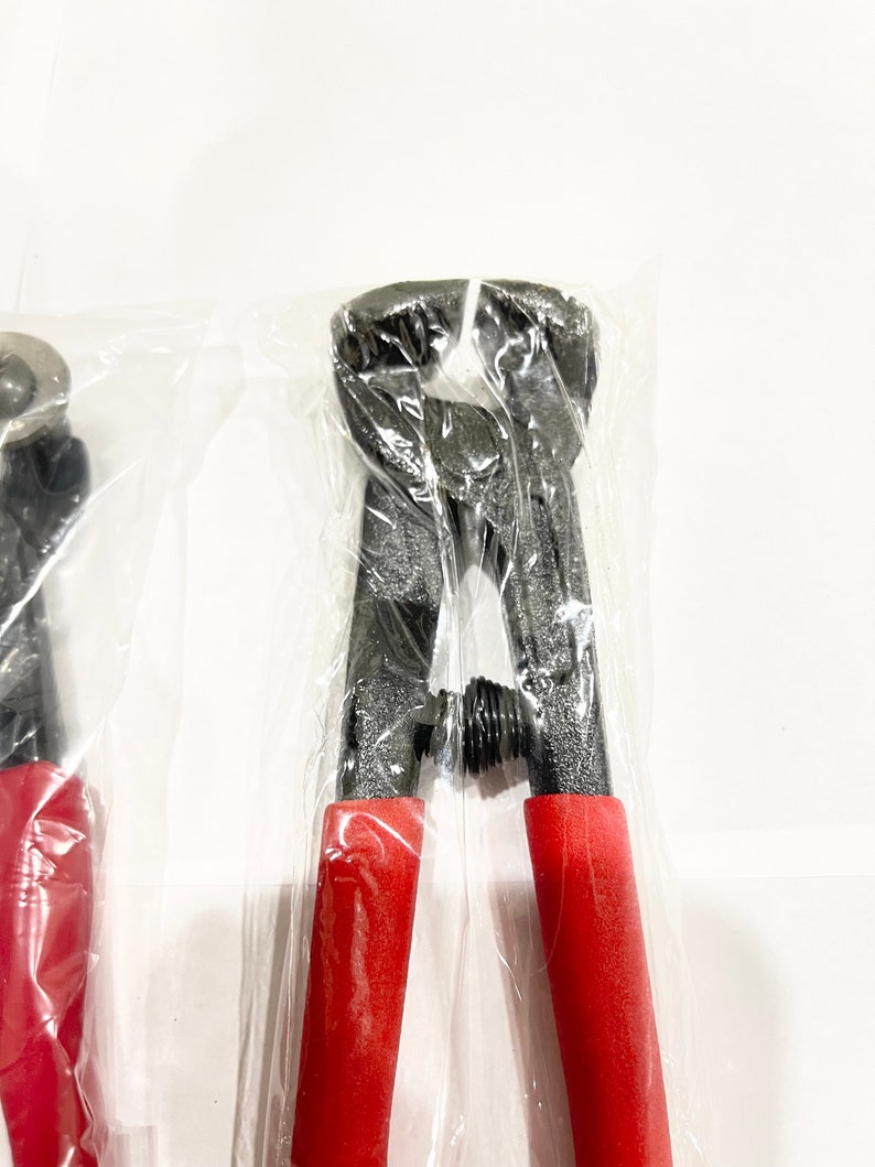 May include: A pair of black metal wire cutters with red handles, packaged in plastic.