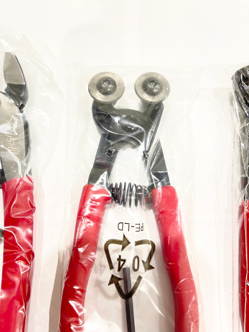 May include: A pair of red-handled wire cutters with a spring mechanism and a black metal blade. The cutters are packaged in a clear plastic bag with a recycling symbol that reads "04 PE-LD".