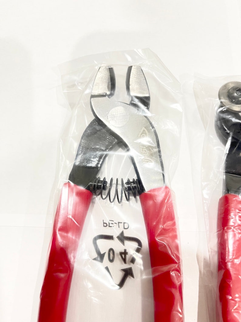 May include: A pair of red-handled wire cutters in a clear plastic bag. The cutters have a spring-loaded handle and a black metal head. The bag has a recycling symbol with the text "PE-TD 04".