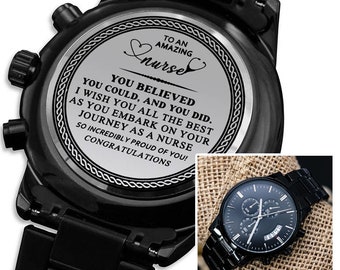 May include: Black wristwatch with a black band and a silver face. The watch face has a message engraved on it that reads "To an amazing nurse. You believed you could, and you did. I wish you all the best as you embark on your journey as a nurse. So incredibly proud of you! Congratulations."