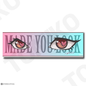 Puede incluir: Una pancarta con degradado rosa y azul con el texto "MADE YOU LOOK" en blanco. Dos ojos grandes de dibujos animados con pupilas rojas y corazones rosas a cada lado del texto.