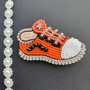 Broche deportivo naranja con cuentas hecho a mano
