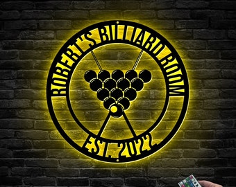May include: A black metal sign with a yellow glow, featuring the text "Robert's Billiard Room Est. 2022" and a graphic of a rack of billiard balls.