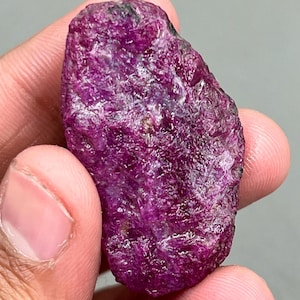 以下が含まれることがあります： 大きな、粗い、濃いピンク色のルビーの原石。ルビーは深みのある豊かな色合いをしており、研磨されていない天然石です。