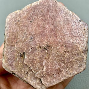 以下が含まれることがあります： 六角形の大きなピンクのルビーの原石。結晶は自然な研磨されていない仕上げで、内包物の兆候が見られます。