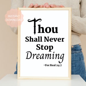 Könnte beinhalten: Ein gerahmter Druck mit einem schwarz-weißen inspirierenden Zitat, das lautet "Thou Shall Never Stop Dreaming - For Real 24:7".