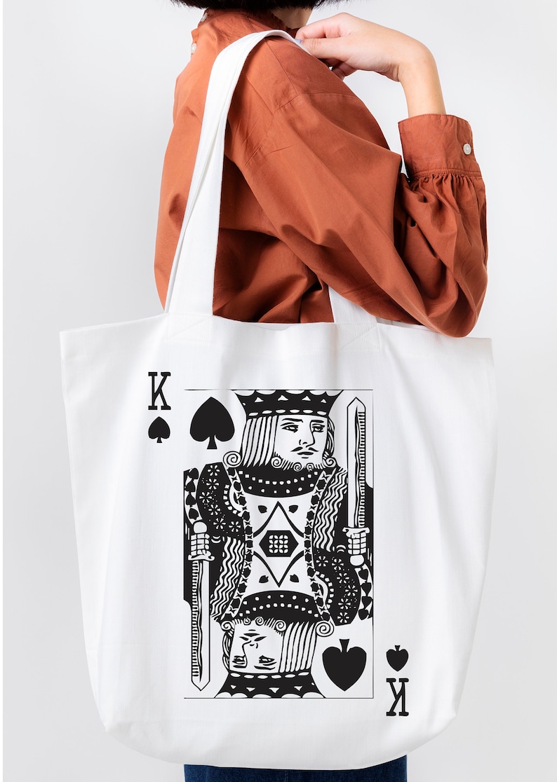 May include: White canvas tote bag with a black and white illustration of the King of Spades playing card.