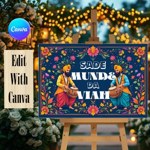 May include: A rectangular sign on a wooden easel featuring a dark blue background with a colourful floral border. Two figures in traditional attire play drums, flanking the white text that reads SADE MUNDE DA VIAH in a bold, blocky font.