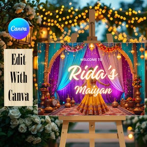 Op de afbeelding: Een decoratief evenementenbord op een houten ezel met een levendige scène met blauwgroene en paarse gordijnen, bloemenslingers en gouden lantaarns. De tekst luidt Welcome to Rida's Maiyan. Een persoon draagt een gele jurk in de afbeelding.