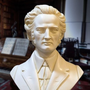 Puede incluir: Busto de yeso blanco del compositor Fr&eacute;d&eacute;ric Chopin, con corbata y chaqueta blancas, sobre una base negra con las palabras "CHOPIN" y "DECORAR.CON.ARTE" inscritas.